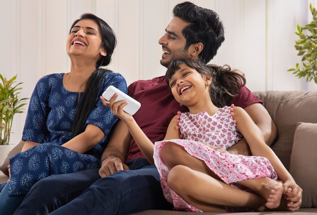 Family laughing on the couch.